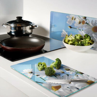 Tábua para corte Flores de margarida em um fundo azul