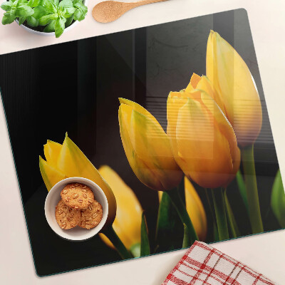 Tábua para corte Tulipas amarelas em um fundo preto