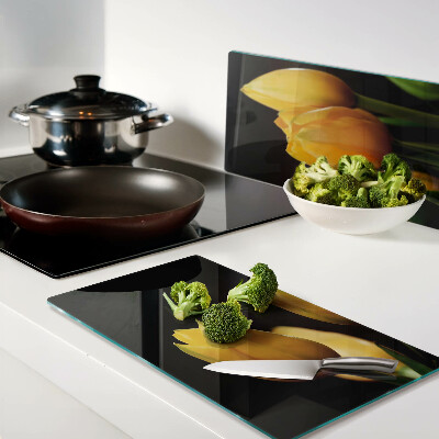 Tábua para corte Tulipas amarelas em um fundo preto