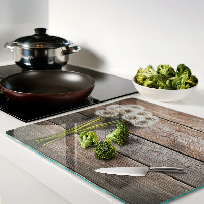 Tábua para corte Flores de dente-de-leão em um fundo de madeira