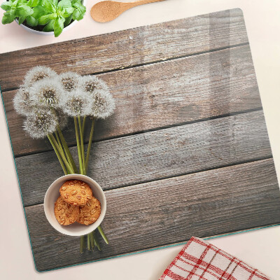 Tábua para corte Flores de dente-de-leão em um fundo de madeira