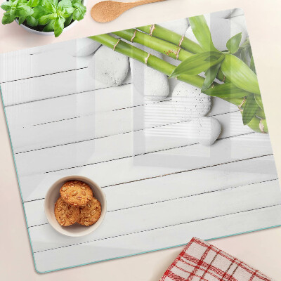 Tábua para corte Bambu e pedras sobre fundo de madeira