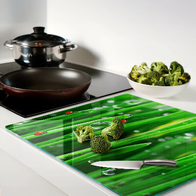 Tábua para corte Gotas de água na grama com joaninhas