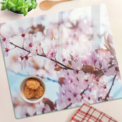 Tábua para corte Flores de cerejeira em um fundo azul