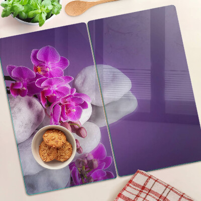 Tábua para cozinha Flores de orquídea em um fundo de pedras