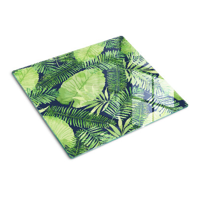 Tábua para corte Folhas tropicais em um fundo escuro