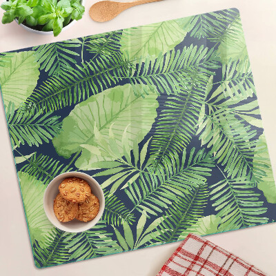 Tábua para corte Folhas tropicais em um fundo escuro