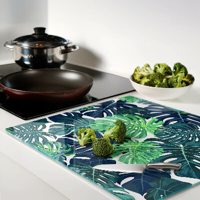 Tábua para corte Folhas de Monstera em um fundo tropical