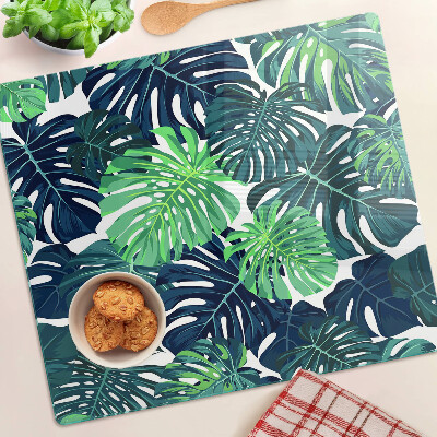 Tábua para corte Folhas de Monstera em um fundo tropical