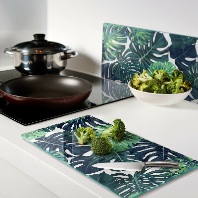 Tábua para corte Folhas de Monstera em um fundo tropical