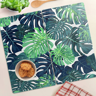 Tábua para corte Folhas de Monstera em um fundo tropical