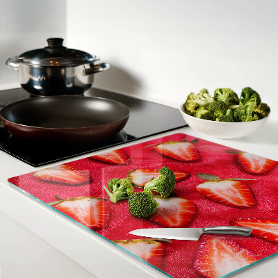 Tábua para corte Morangos em um fundo rosa