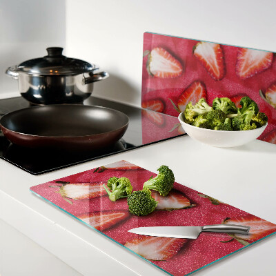 Tábua para corte Morangos em um fundo rosa