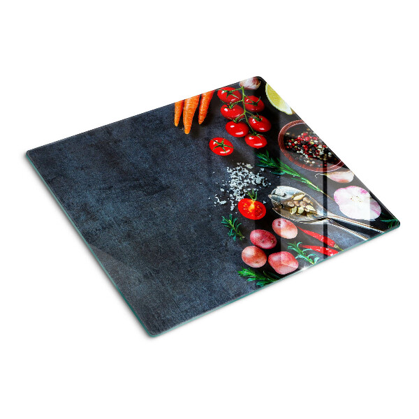 Tábua para cozinha Legumes e especiarias em um fundo escuro