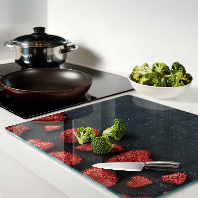 Tábua para corte Corações vermelhos em um fundo escuro