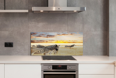 Painel de vidro Pôr do sol no campo de zebras