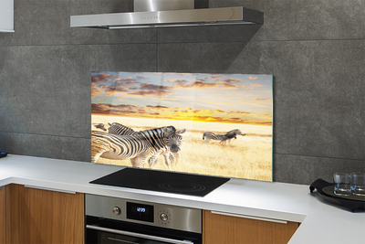 Painel de vidro Pôr do sol no campo de zebras