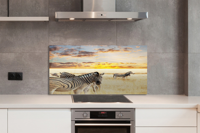 Painel de vidro Pôr do sol no campo de zebras