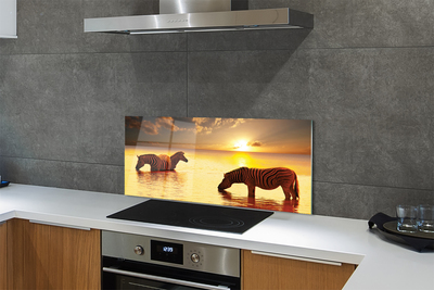 Painel de vidro Zebras na água do pôr do sol