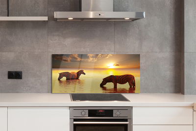 Painel de vidro Zebras na água do pôr do sol