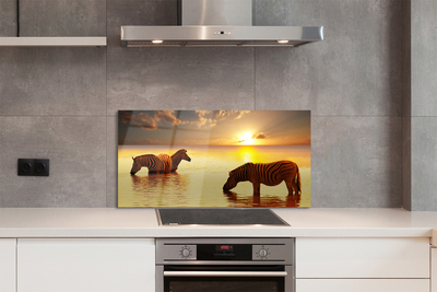 Painel de vidro Zebras na água do pôr do sol