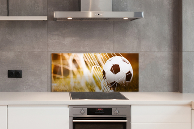 Painel de vidro Bola amarela em fundo de grama