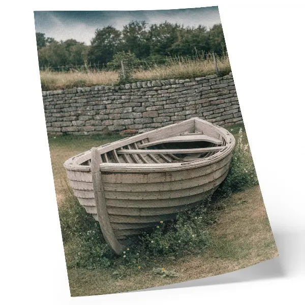 Pôster decorativo com barco abandonado, grama e natureza em uma parede serena