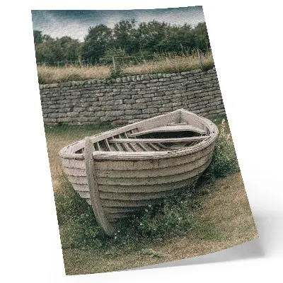 Pôster decorativo com barco abandonado, grama e natureza em uma parede serena