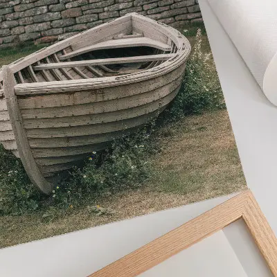 Pôster decorativo com barco abandonado, grama e natureza em uma parede serena