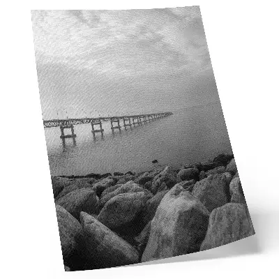 Poster para cozinha com paisagem tranquila de ponte em praia rochosa sob céu cinzento