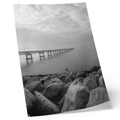 Poster para cozinha Paisagem tranquila, ponte, praia rochosa, céu cinzento.