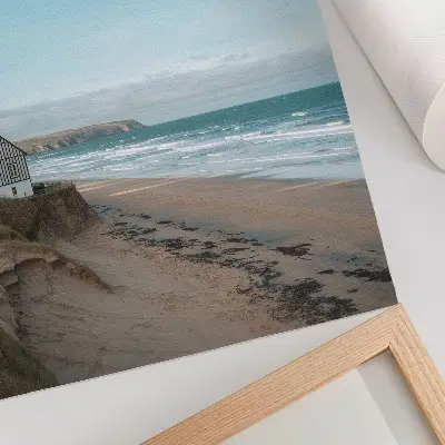 Impressão em tela praia com ondas e casa em um penhasco em cores pastel