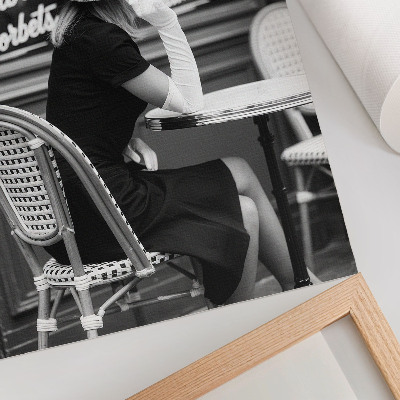 Arte de parede Uma mulher usando chapéu sentada à mesa em um café.