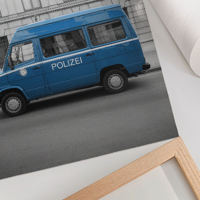 Impressão em tela Um carro de polícia azul com um prédio ao fundo.