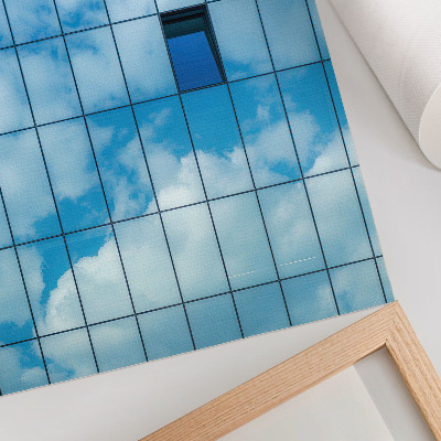Impressão em tela Uma fachada de vidro que reflete o céu e as nuvens.