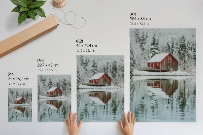 Arte de parede Uma cabana vermelha entre árvores cobertas de neve à beira da água.