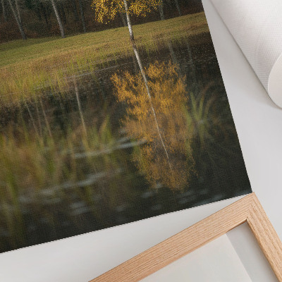Poster decorativo Uma árvore dourada em contraste com a escuridão da floresta e do lago.
