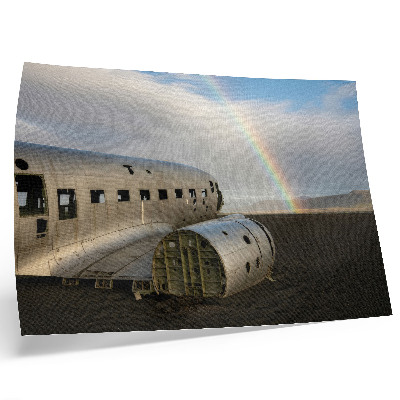 Poster em tela Os destroços de um avião de metal com um arco-íris ao fundo.