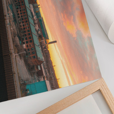Poster em tela Prédios industriais ao pôr do sol, atmosfera tranquila.