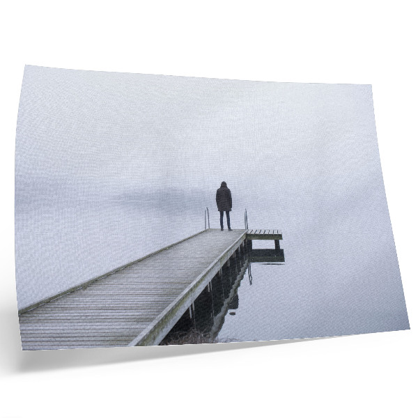 Poster Uma figura solitária num cais em meio à neblina.