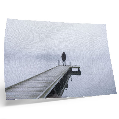 Poster Uma figura solitária num cais em meio à neblina.