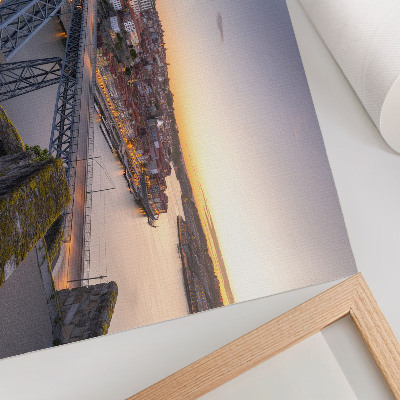 Poster A ponte com o pôr do sol e a cidade ao fundo.