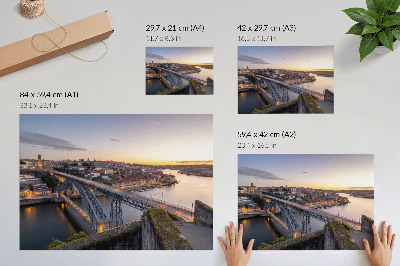 Poster A ponte com o pôr do sol e a cidade ao fundo.