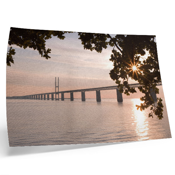 Poster em tela Uma ponte pitoresca ao pôr do sol sobre a água.