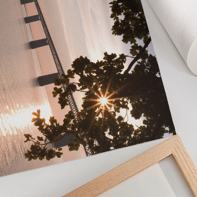 Poster em tela Uma ponte pitoresca ao pôr do sol sobre a água.
