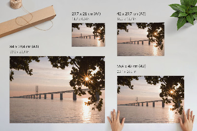Poster em tela Uma ponte pitoresca ao pôr do sol sobre a água.