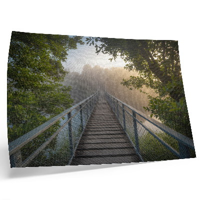 Poster em tela Uma ponte na neblina sobre um rio em meio à vegetação.