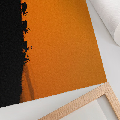 Poster Silhuetas de veados em uma colina com fundo laranja.