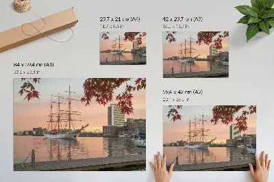 Pôster veleiro ao pôr do sol em um panorama tranquilo da cidade