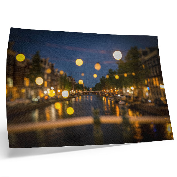 Poster em tela Uma cidade encantadora à noite, com luzes refletidas na água.